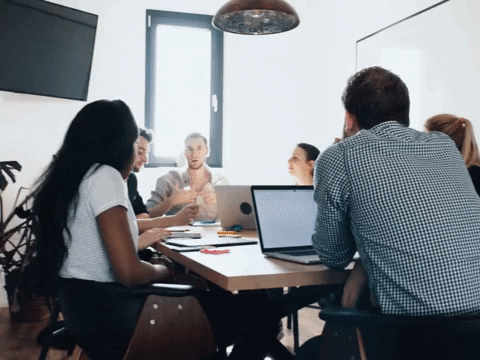 Employees in a collaborative meeting with laptops, discussing strategies for AI consulting for businesses.