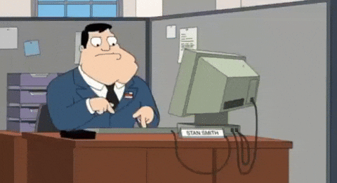 Animated GIF of a man typing slowly at an office desk, illustrating the inefficiency caused by unstructured AI prompt development.